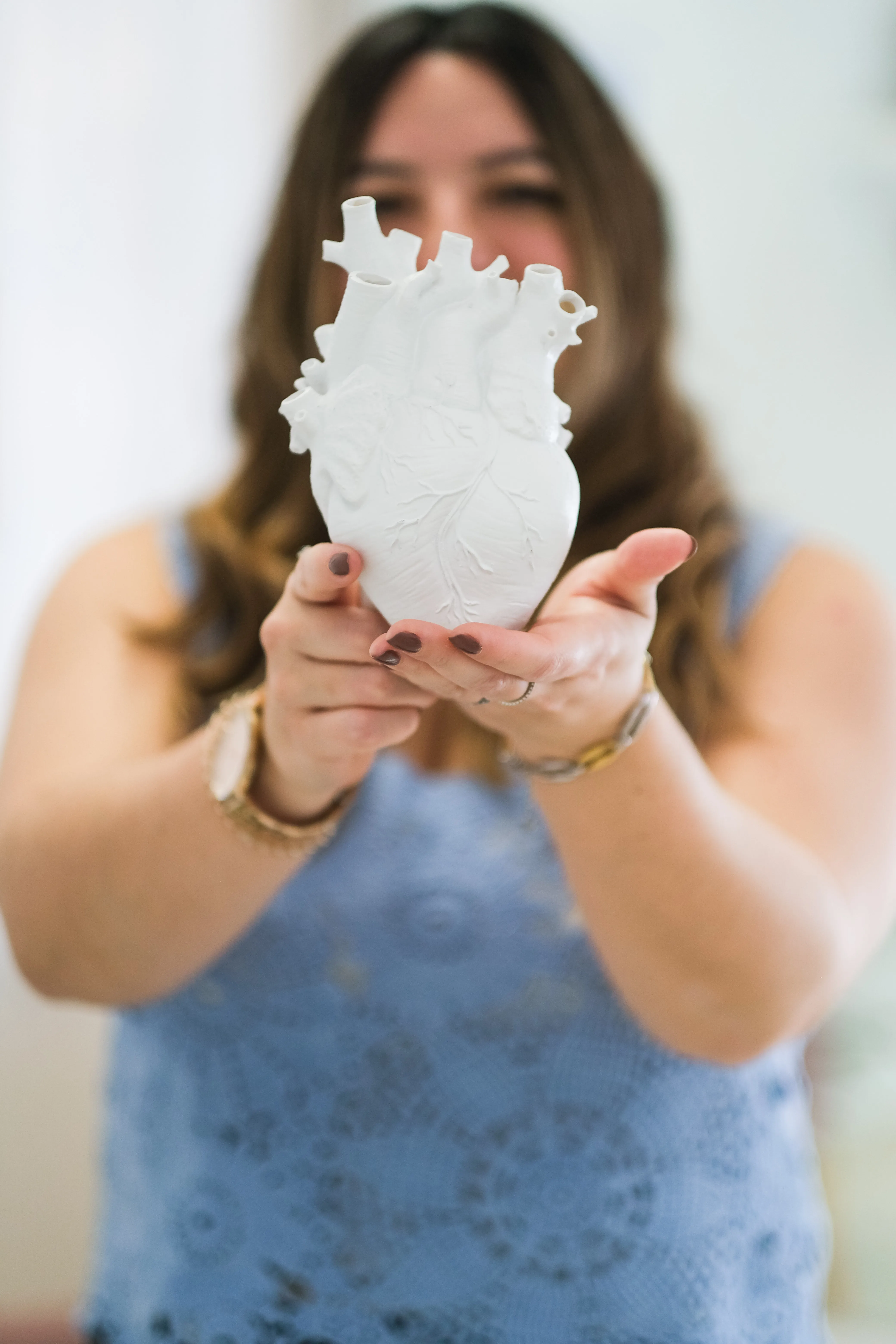 Laura sosteniendo una escultura de corazón anatómico